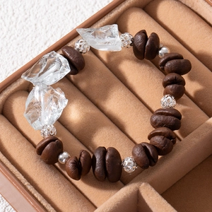 Close-up of coffee bean style beads and irregular crystal beads in a brown velvet gift box