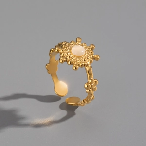 Detailed macro view of a gold sunflower ring with opal inlay and textured band