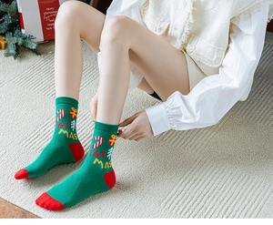Détail de chaussettes de Noël avec motifs festifs et lettrage tricoté sur la cheville