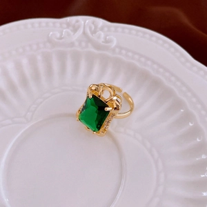Macro shot of rectangular emerald green zircon ring with vintage gold setting details