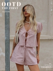 Détail de l'ensemble vichy rose avec nœuds frontaux et texture des manches bouffantes