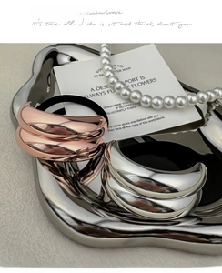Detail of rose gold and silver metal hair ties with mirror finish on wave tray