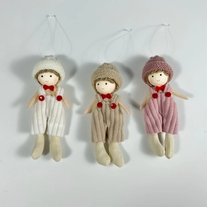 Close-up of three knitted Christmas gnome ornaments in white, beige, and pink finishes