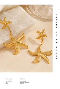 Detailed macro view of golden starfish earrings featuring textured double drop sea star design