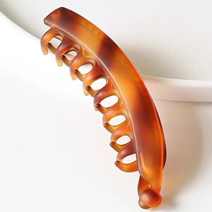 Close-up of minimalist amber matte banana hair clip showing its smooth texture and elegant curve