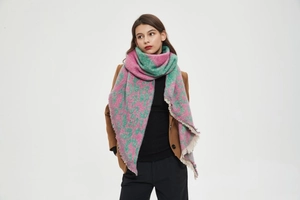 Detail of pink and green plaid scarf featuring cozy bouclé yarn and stylish fringe edges