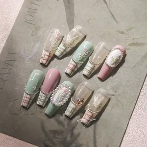 Detail of sweet French press-on nails with 3D tulips, pearls, and butterfly patterns
