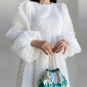 White crew neck puff sleeve dress with 3D bubble texture and green sequined handbag