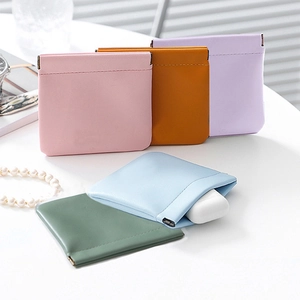 Detailed view of colorful PU leather self-closing pouches with a mini earphone case inside
