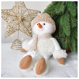 Detail of plush snowman with knit cap and carrot nose in warm holiday scene decor