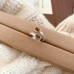 Macro detail of oval tiger eye stones on a vintage silver crisscross adjustable ring