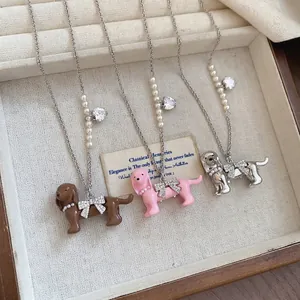 Three dachshund necklaces with pearls, bowknots and crystals in a vintage jewelry box