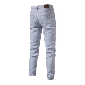 Detail of light blue denim jeans showing back pockets and leather waist patch
