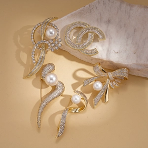 5-piece gold-plated brooch set with faux pearls and zircons on marble background