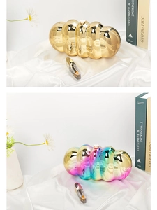 Close-up of wave-textured cloud acrylic clutch bags in metallic gold and iridescent finishes