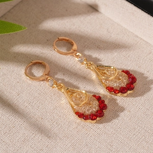 Detailed macro view of vintage gold teardrop earrings with sparkling red stones