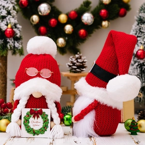 Detailed close-up of handmade Christmas gnomes with red knit hats and festive decorations
