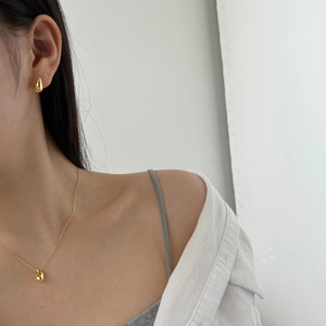 Close-up of gold water drop jewelry set with necklace and earrings on female model