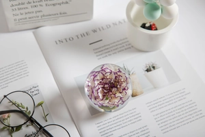 Macro shot of dandelion crystal ball ornament with clear resin flower detail on a desk
