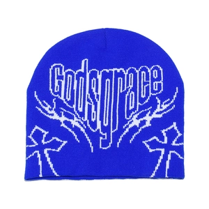 Detail of bright blue knitted beanie featuring white Godsgrace lettering and gothic crosses