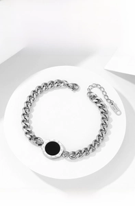 Detail of silver stainless steel curb chain bracelet with Roman numeral round pendant