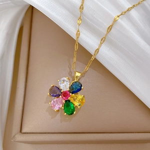 Macro detail of rotating floral pendant with colorful gems and gold-plated chain