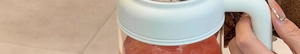 Close-up of clear high borosilicate glass mug with white handle and pink tea