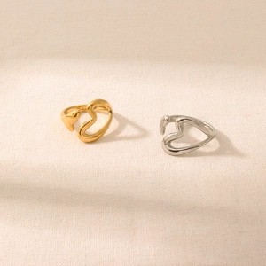 Minimalist 18K gold and silver plated open heart rings shown on beige fabric texture