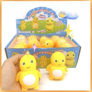 Detailed view of yellow dragon squeeze toys in a blue display box for kids
