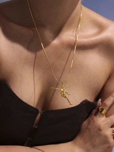 Close-up of elegant 18k gold ballerina pendant with 5A zircons on a double layer necklace