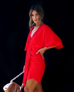 Détail de la robe rouge à col en V avec manches chauve-souris et drapé à la taille