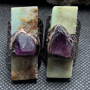 Detail view of vintage adjustable rings with raw purple amethyst and green rectangle stones