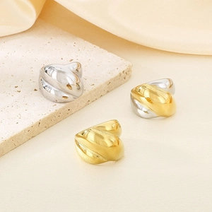 Close-up of twisted stainless steel rings in gold and silver finish on stone plates
