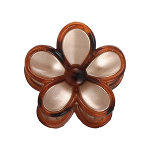 Macro detail of amber flower hair claw clip with pearlescent petals on white background