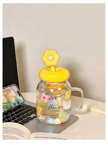 Detail of clear glass tumbler with yellow floral silicone lid and matching straw design