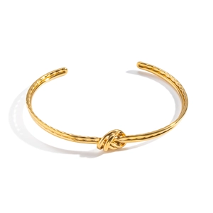 Bracelet jonc avec nœud minimaliste en acier inoxydable plaqué or 18 carats sur fond blanc