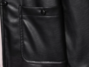 Detail of black leather jacket pocket featuring fine stitching and premium texture