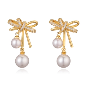 Elegant gold bow earrings with shimmering zircons and hanging white pearls