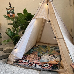Detail of bohemian woven blanket with artistic tiger pattern inside a camping teepee tent