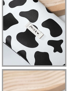 Detail of soft leather cow print glasses pouch with magnetic snap and milky label