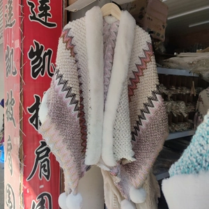 Ethnic knit poncho with faux rabbit fur trim and decorative white tassels in zigzag pattern