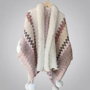 Ethnic knit poncho with faux rabbit fur trim and decorative white tassels in zigzag pattern