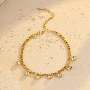 Detail of adjustable gold Cuban chain bracelet featuring seven clear round zircons