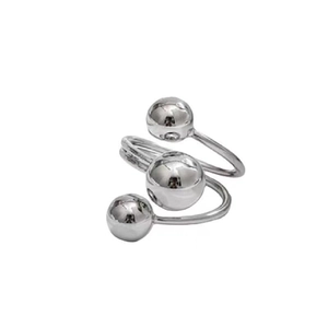 Detail eines silbernen Kupferrings mit gedrehtem Design und drei kugelförmigen Enden