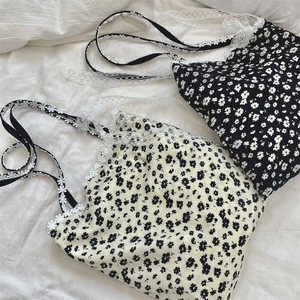 Detail of floral canvas tote bag featuring delicate lace shoulder straps and bow accents