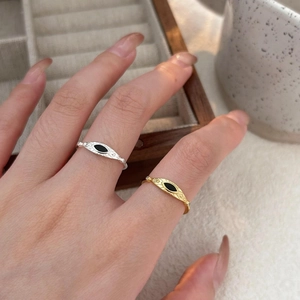 Close-up of silver and gold 925 sterling silver rings with black eye motif and star patterns