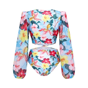 Détail du maillot de bain floral à manches longues avec découpe torsadée et manches bouffantes