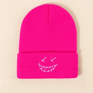 Detailed close-up of rose red ribbed knit beanie featuring white embroidered smiley face