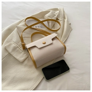 Detail of mini two-tone litchi leather bag in beige and ginger yellow with flap cover