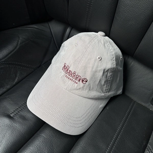 Détail de la broderie Maine avec motif léopard rose sur une casquette en coton gris clair